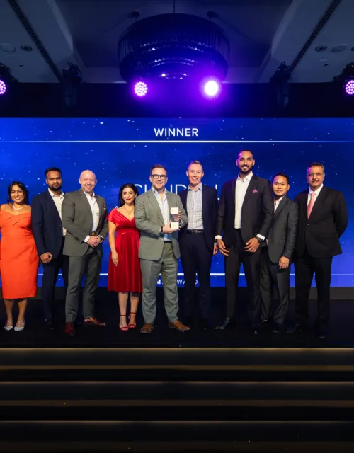 Ten people in formal attire stand on a stage at an awards event. Behind them, a large blue screen displays the text: “Mechanical Electrical Plumbing AWARDS,” “WINNER,” and “RETROFIT PROJECT OF THE YEAR.”