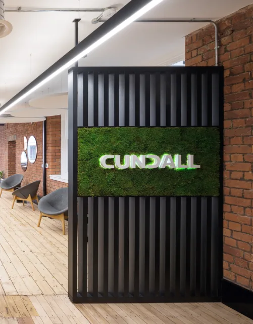 Cundall logo on grass wall hanging in Manchester office