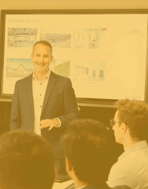 Garrit Schot presenting in a meeting with white screen behind with a yellow overlay