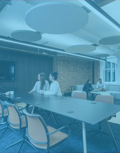 Interior of Cundall Manchester office with seating and table area with a blue overlay