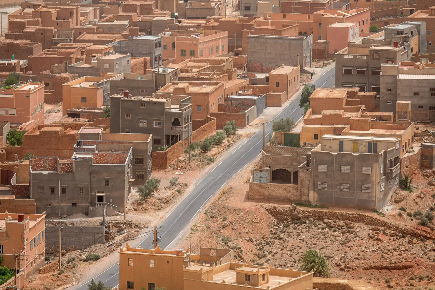 A cityscape of close built red sand and brick residential buildings in the Middle East.