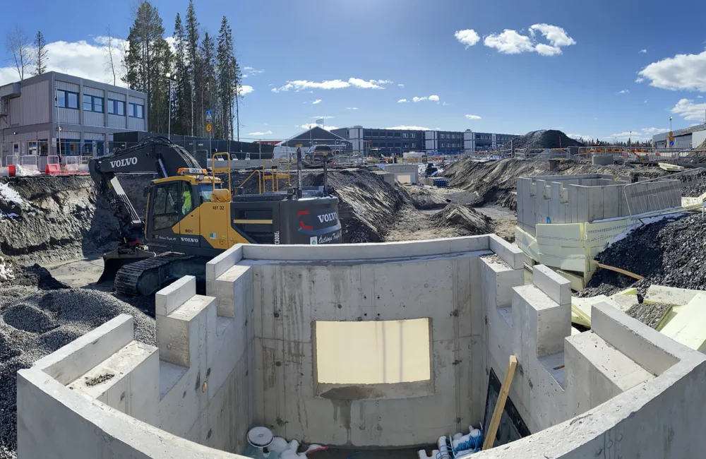 Construction site with diggers and a concrete part built structure