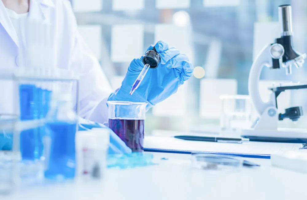 Medical or scientific researcher or man doctor looking at a test tube of clear solution in a laboratory