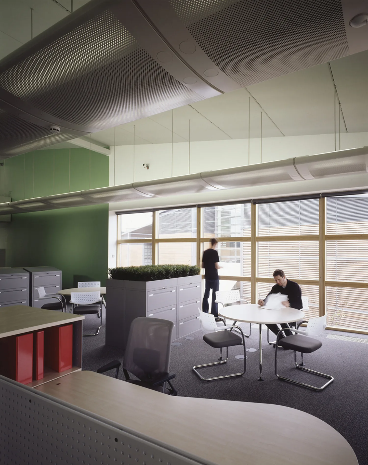 Office interior with desks and tables with people sitting