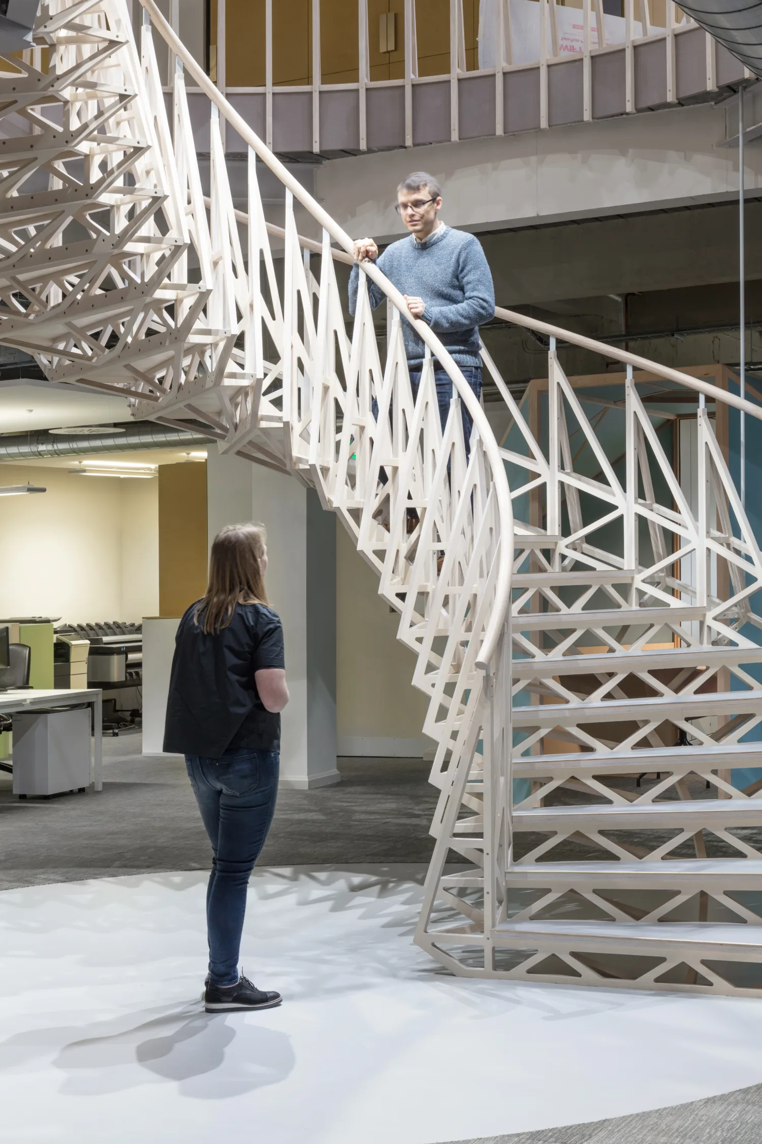 Wooden staircase with person standing on talking to someone at the bottom