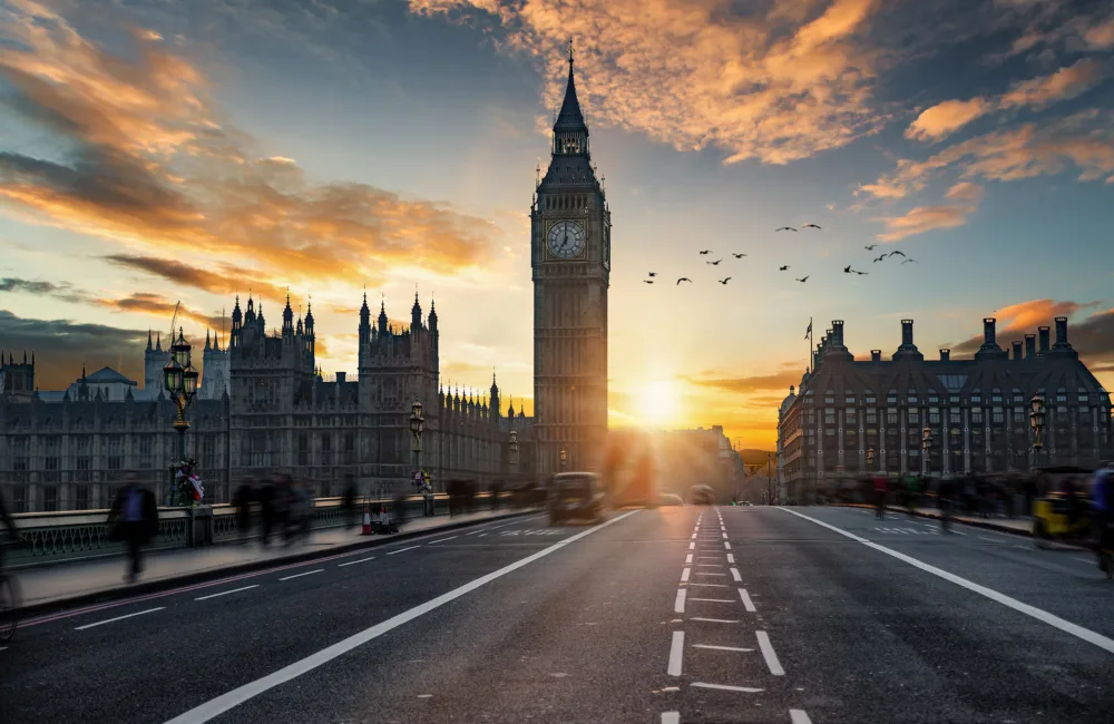 Westminster bridge, Big ben and parliament with the sun setting and flying bird silhouettes