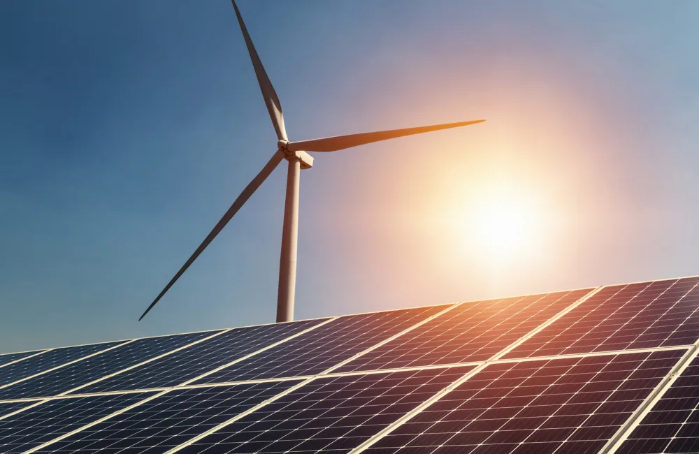 Single wind turbine behind a bank of solar panels
