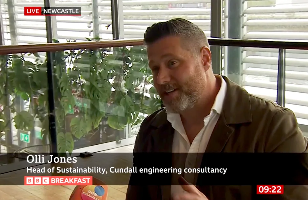 Olli jones talking to a microphone on BBC News