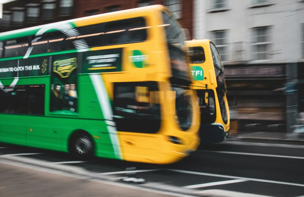 Two Dublin buses in movement on an Irish street