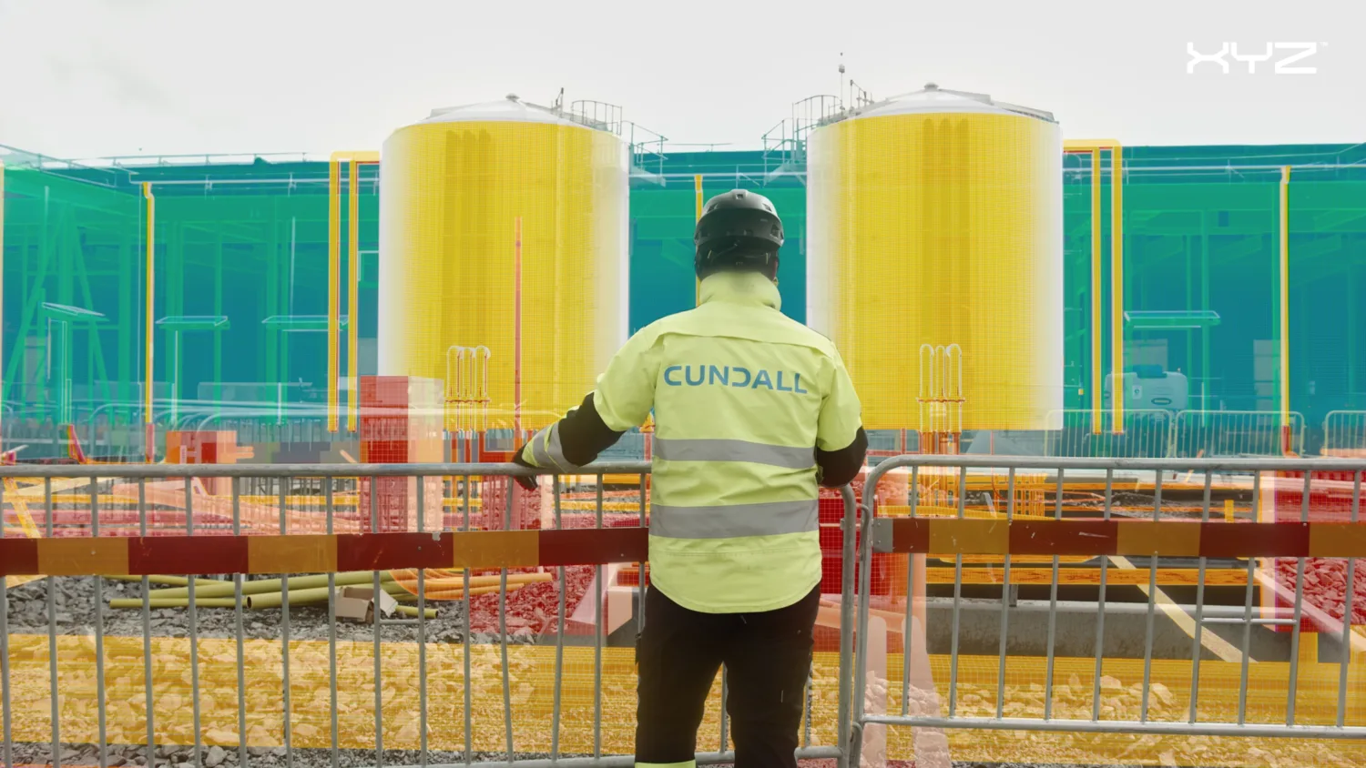 Person with back to camera wearing a Cundall high vis jacket facing a building site with a colourful render superimposed