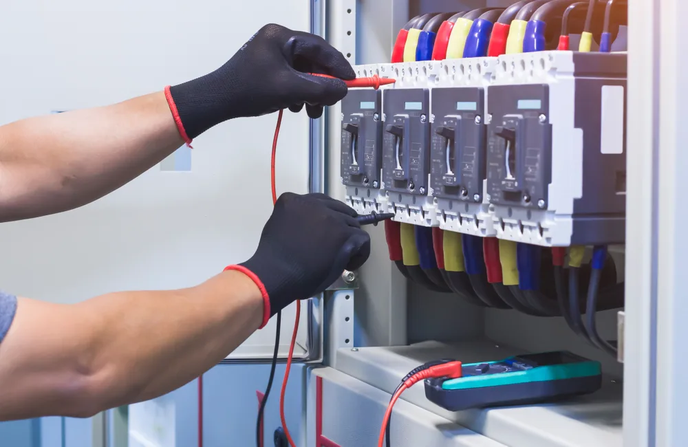 Electrical engineer checking the operation of electrical control cabinet