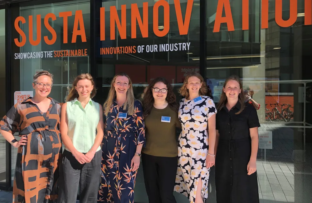 The Sustainnovation team stood in front of the vinyled exhibition windows