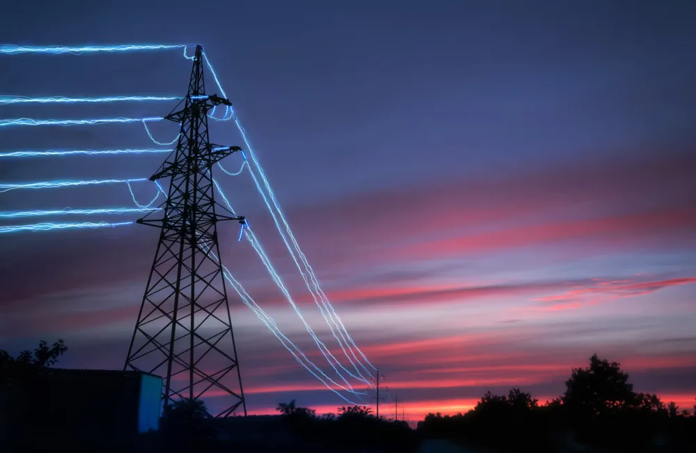 Electricity pylon with blue power cables against a pink blue sky