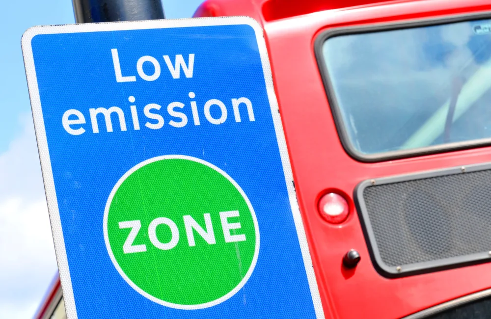 Low emission zone sign in front of a red bus