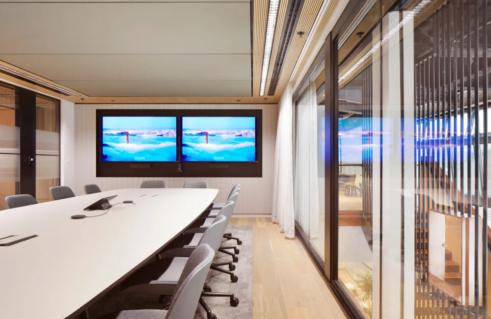 Conference room with long table and two TV screens