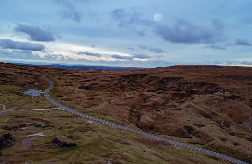 view of road through brecon beacons showing cloudy sky