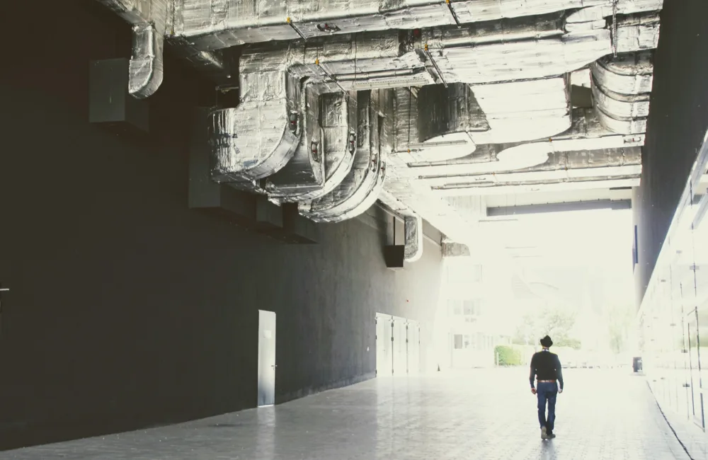 Person stood below large vent pipes