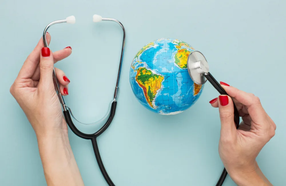 Hands holding stethoscope next to a model of the globe