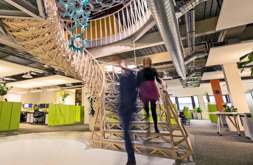 Cundall Birmingham office interior with people walking down the staircase and lighting for the acoustic hanging feature