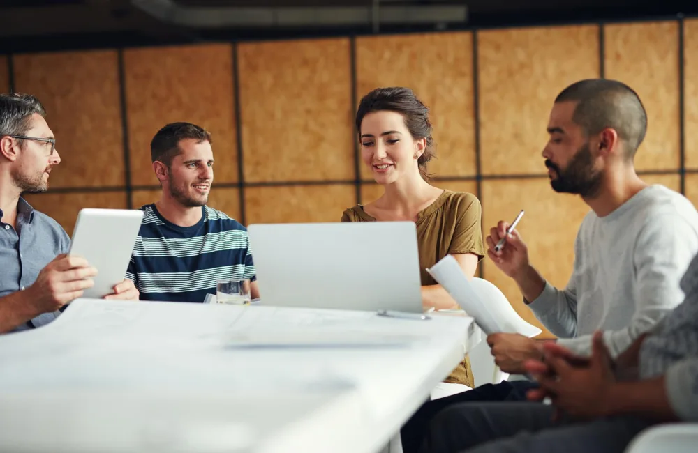 group of coworkers having a meeting in an open plan office
