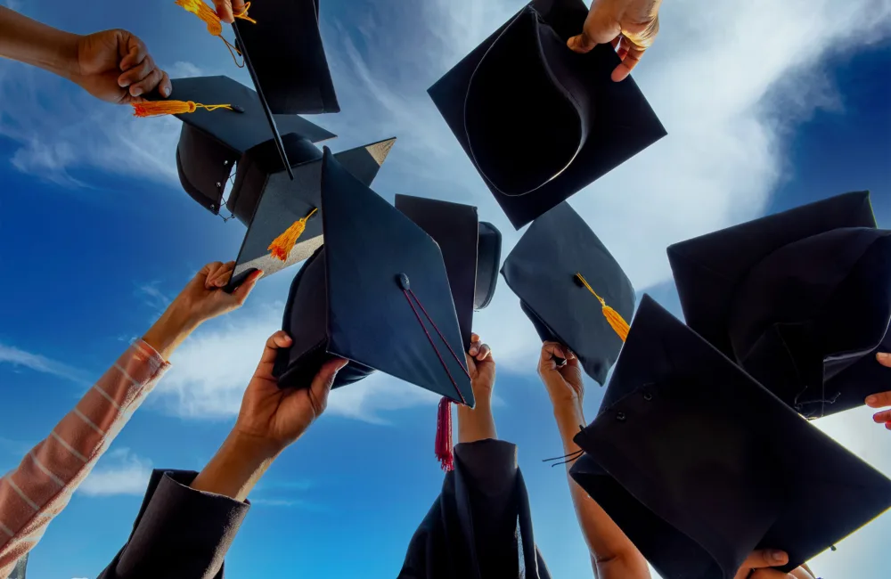 A group of graduates throwing graduation caps in the air