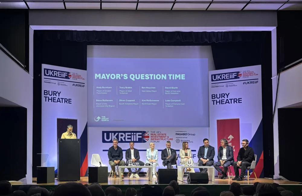 UKREIIF panel on stage with audience watching