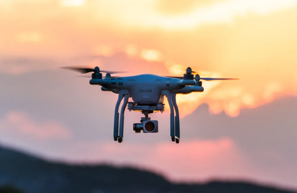 Flying drone against a blurred sunset background