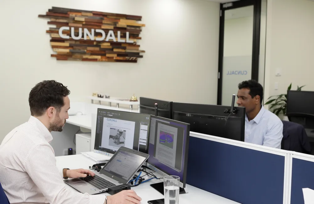 Two men sitting opposite each other, each working on their respective computers in the Cundall Perth office