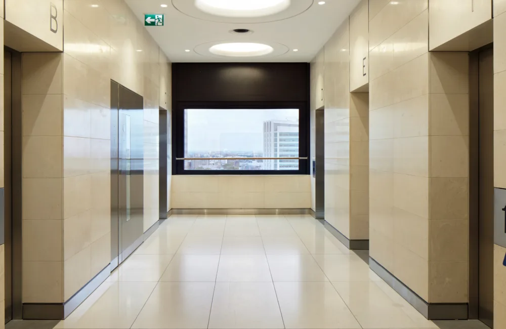 Internal office corridor with at least 4 opposite lifts and two key pads in the foreground