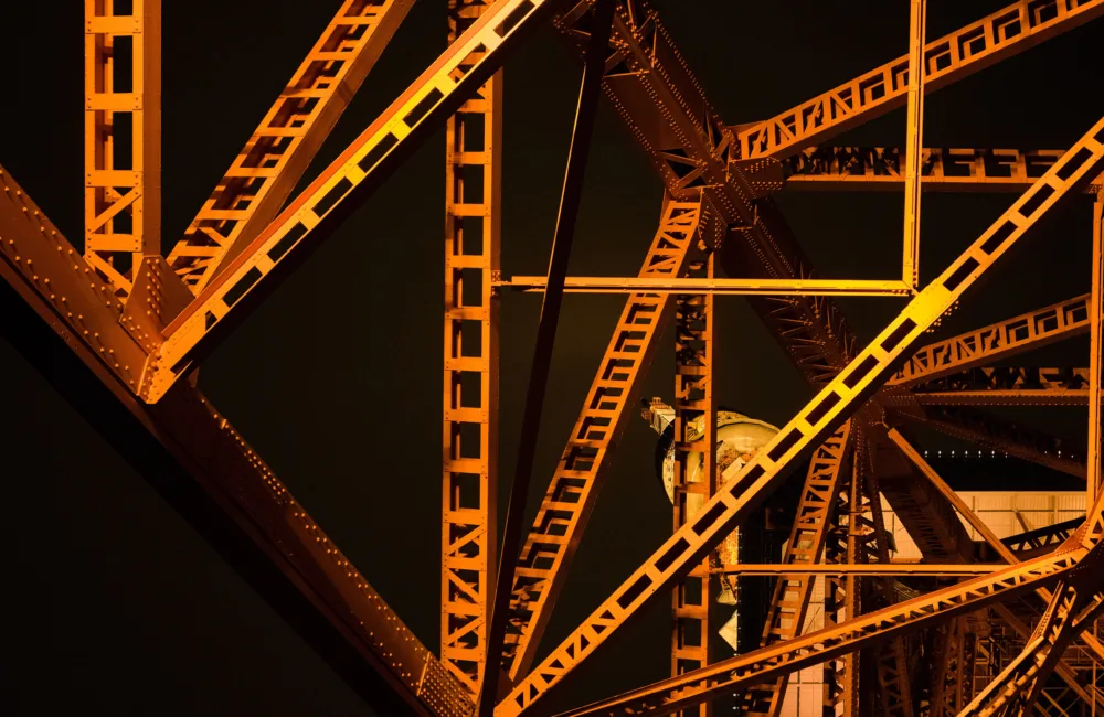 Metal structural elements coloured orange and yellow against a black background