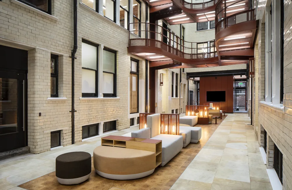 Brick atrium with central seating warm lighting and frosted glass windows
