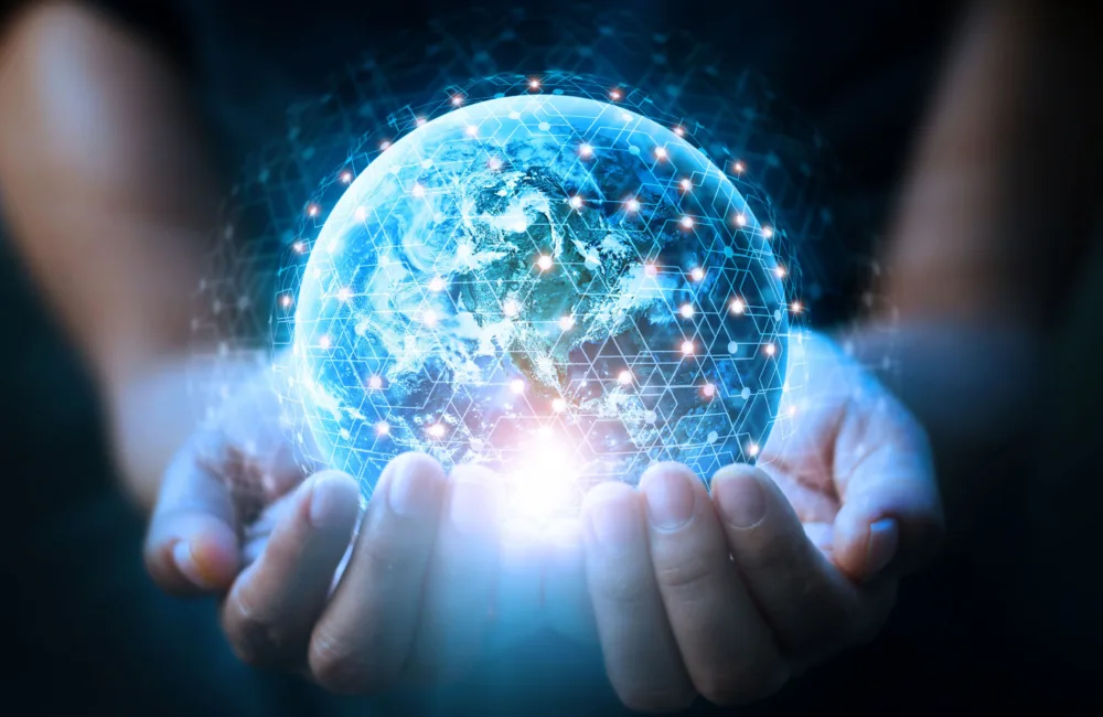 A globe made up of interconnecting glowing lines being held in 2 cupped hands