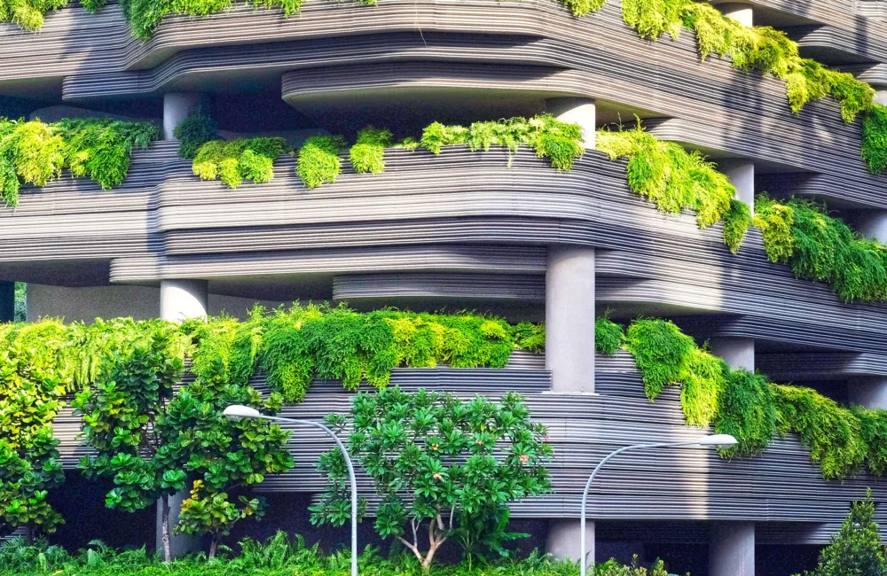 Concrete layered building exterior covered in draping bright green foliage