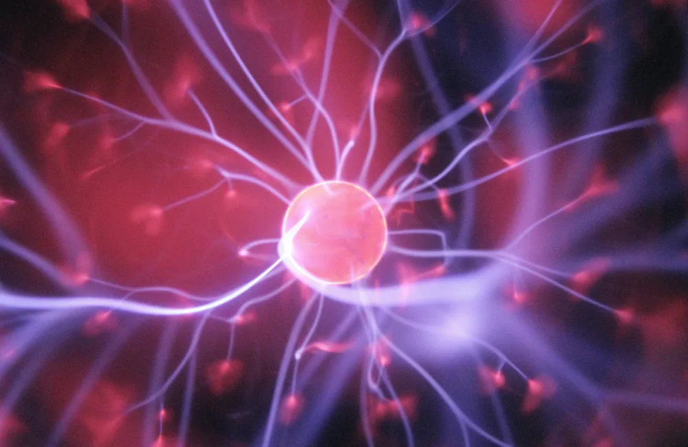 Computer generated image of the interior of a van de graff generator with light purple lines of energy leading to a central pink ball