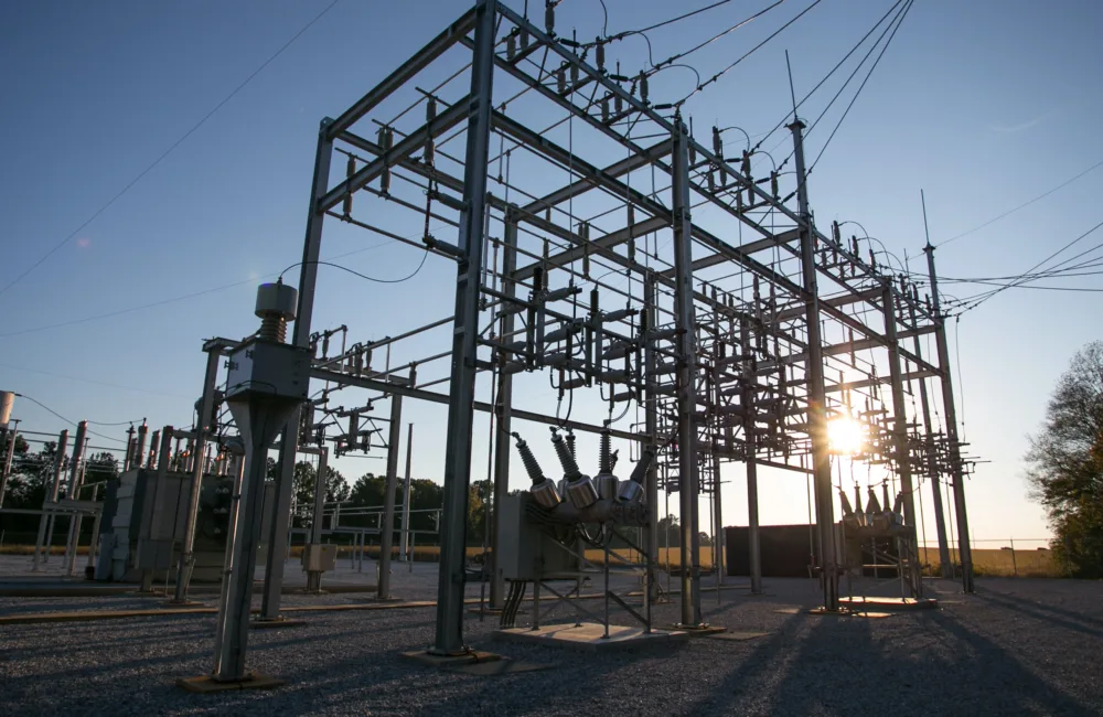 Electric power structure against a blue sky and rising sun