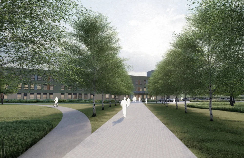 Exterior of Chilmington Green School, a path leads to the building framed by trees and grass