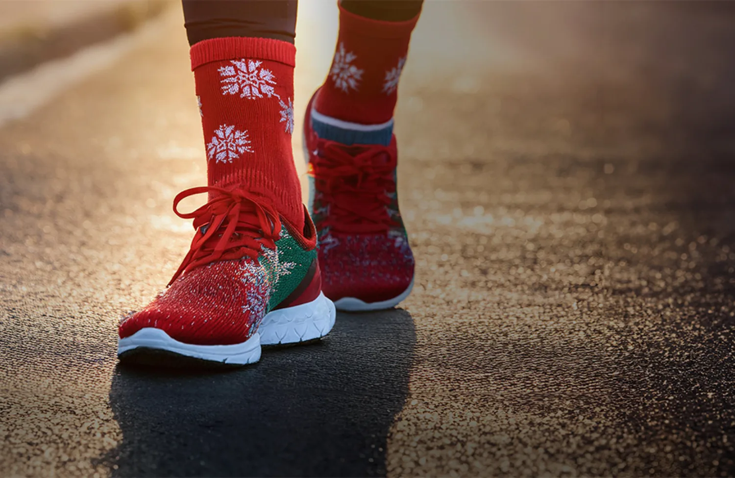 Two feet in red running shoes and Christmas socks on tarmac