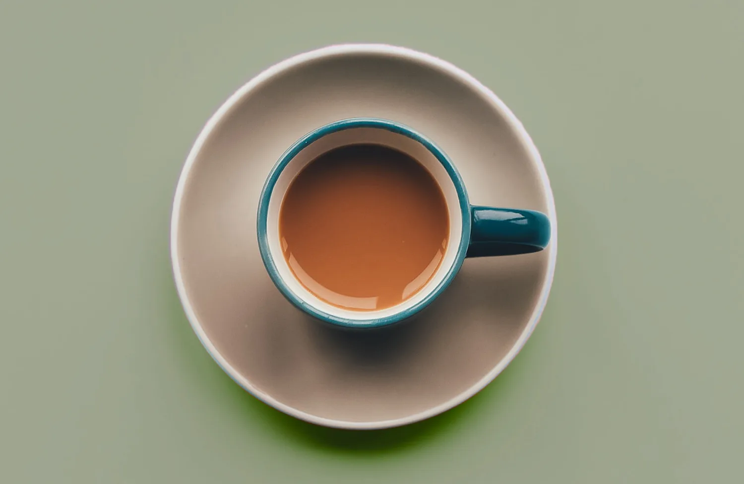 Green background with coffee cup and saucer on it