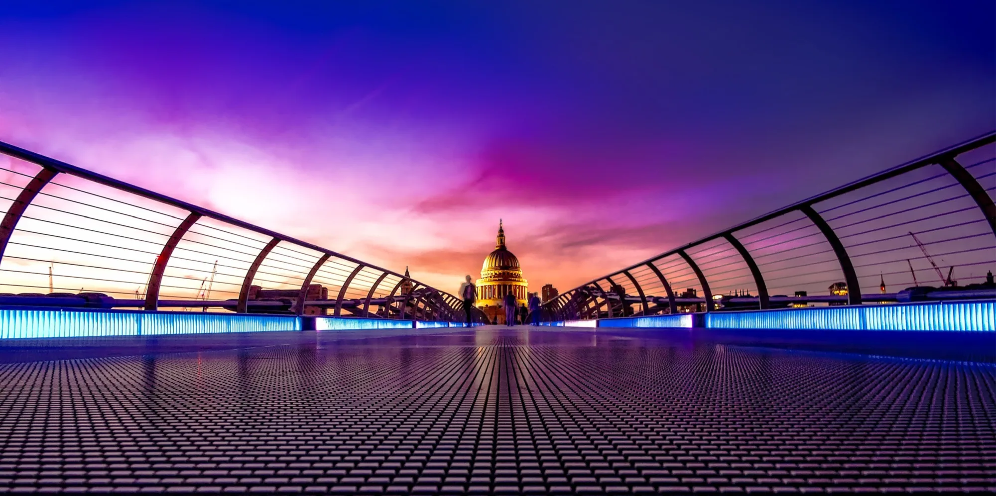 Purple sky over the Millennium Bridge with Saint Pauls Cathedral, London, in the distance