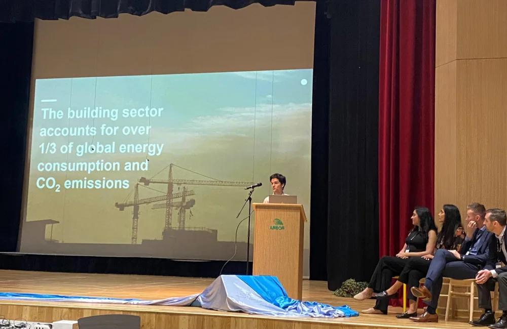 Sustainability engineer on stage behind a podium in front of a projected presentation