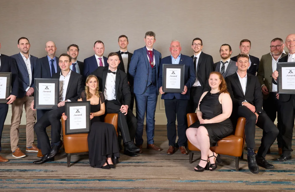 Award winning delegates standing in a room holding certificates