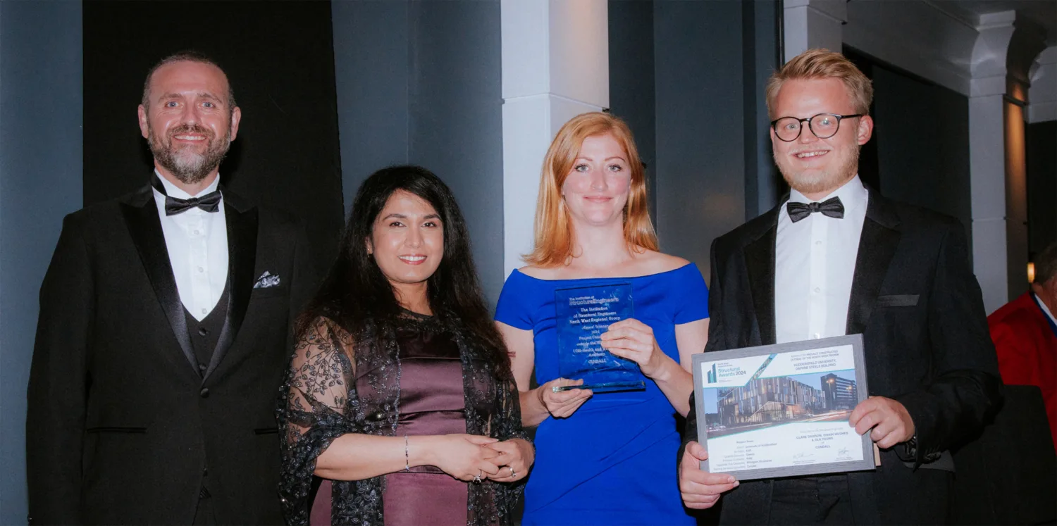 Four people from Cundall in black tie with two people holding awards