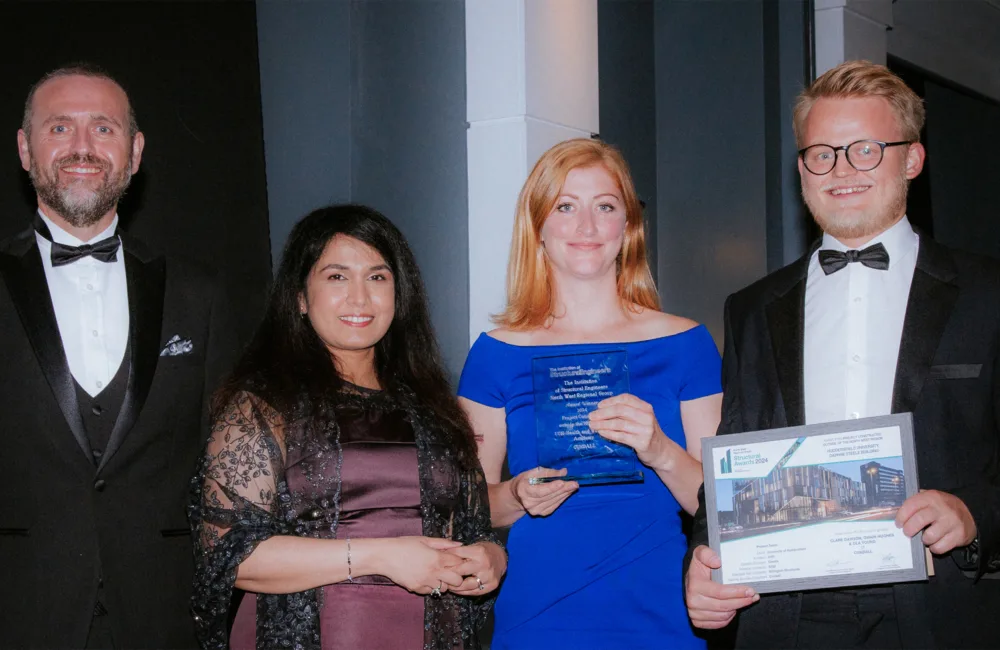 Four people from Cundall in black tie with two people holding awards