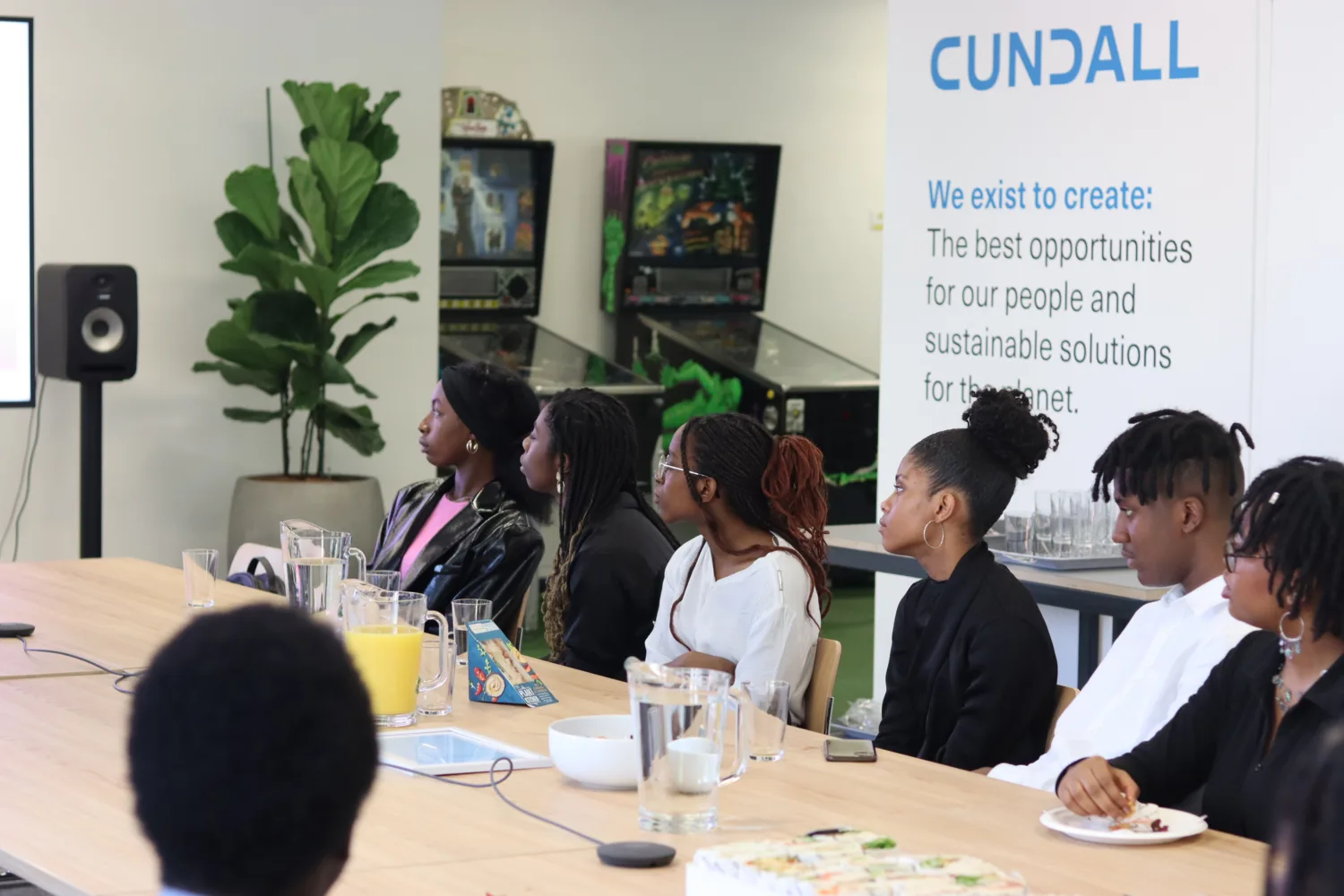 A row of students sat at a board table watching the presentation with Cundall logo in the background
