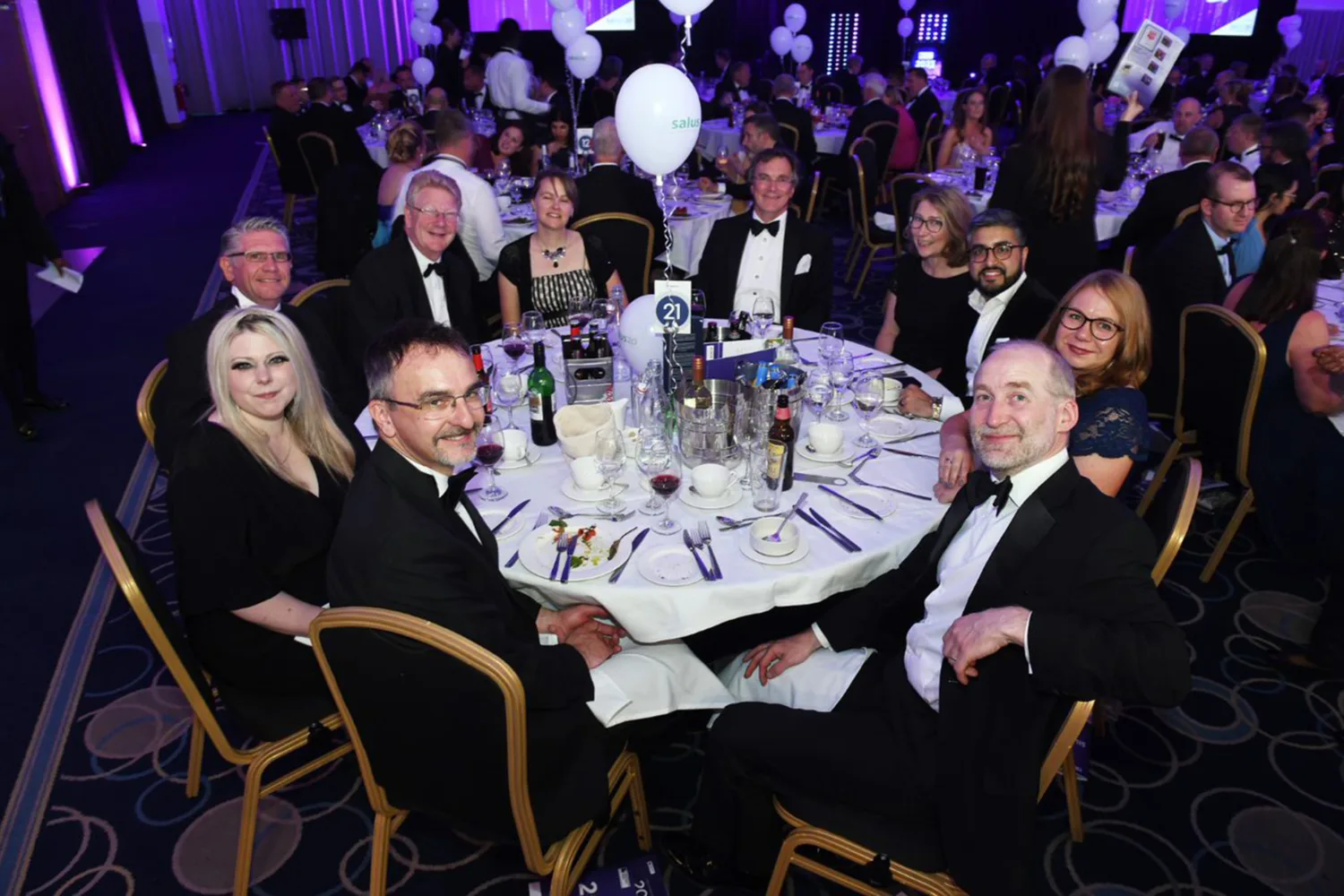 Project team sat round a table smiling at the camera