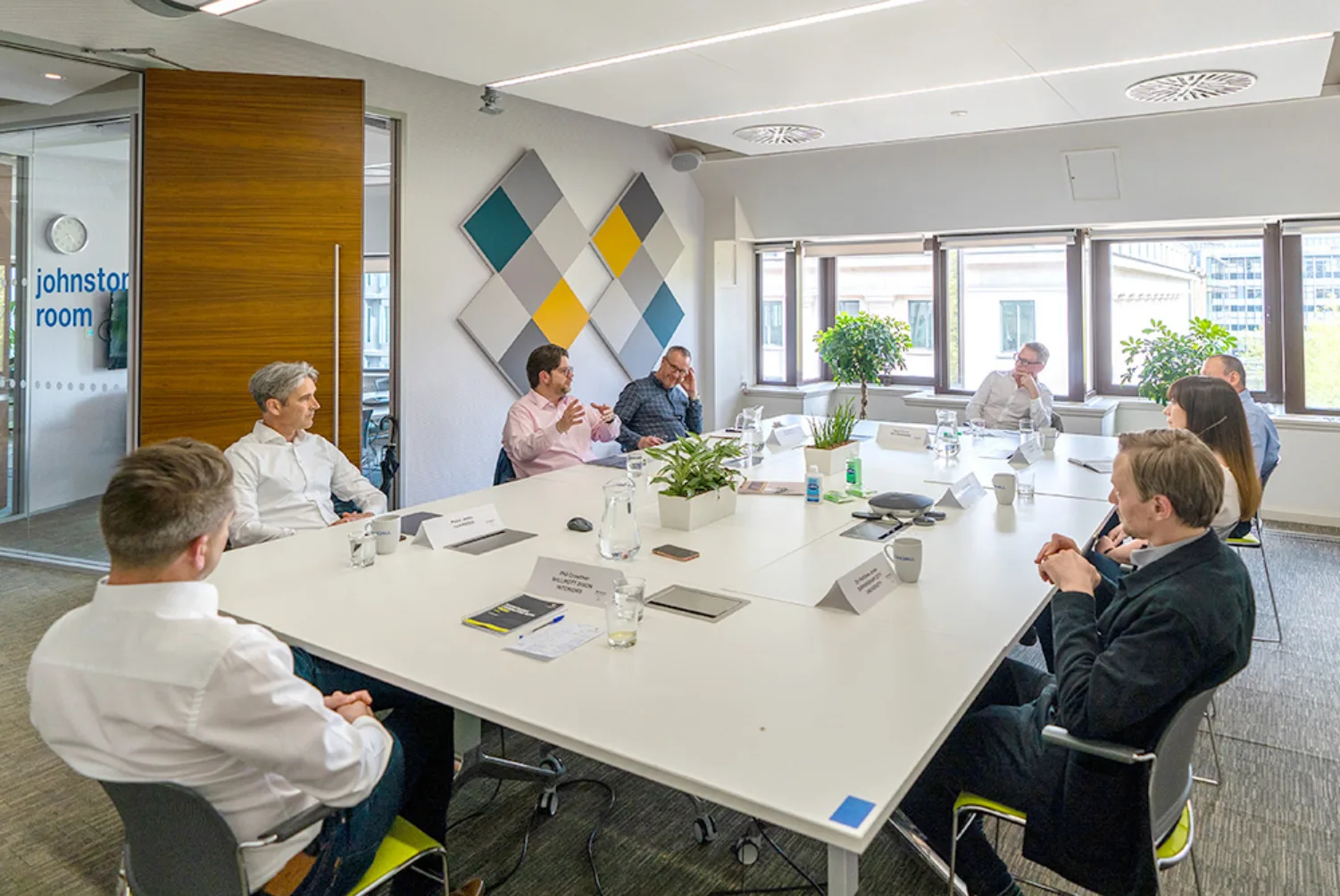 Eight people sat around a large rectangular white table