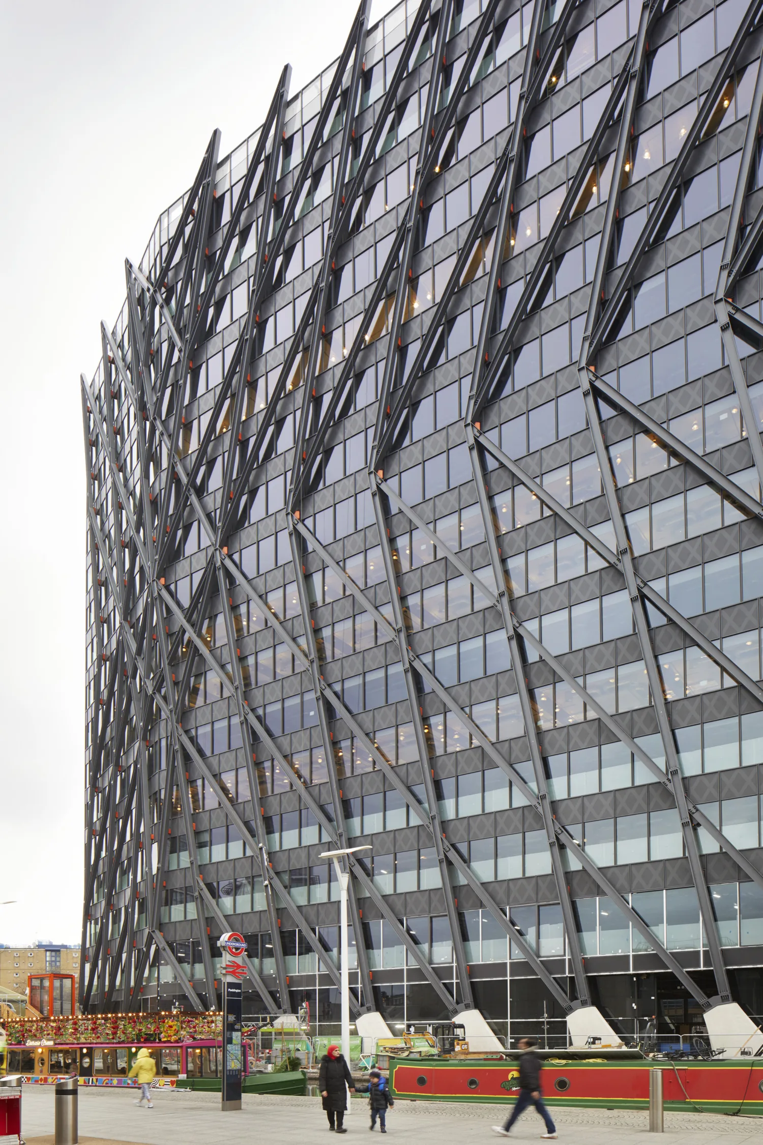 Brunel building with people walking in front of colourful barges
