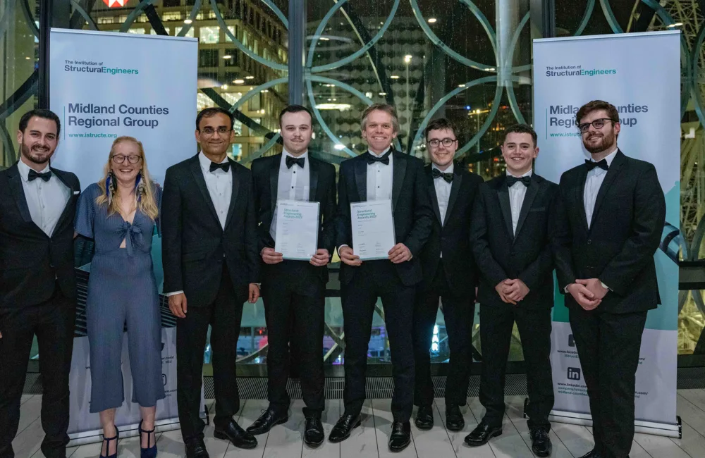 Group of people including Cundall's Alex Carter holding up their awards certificates