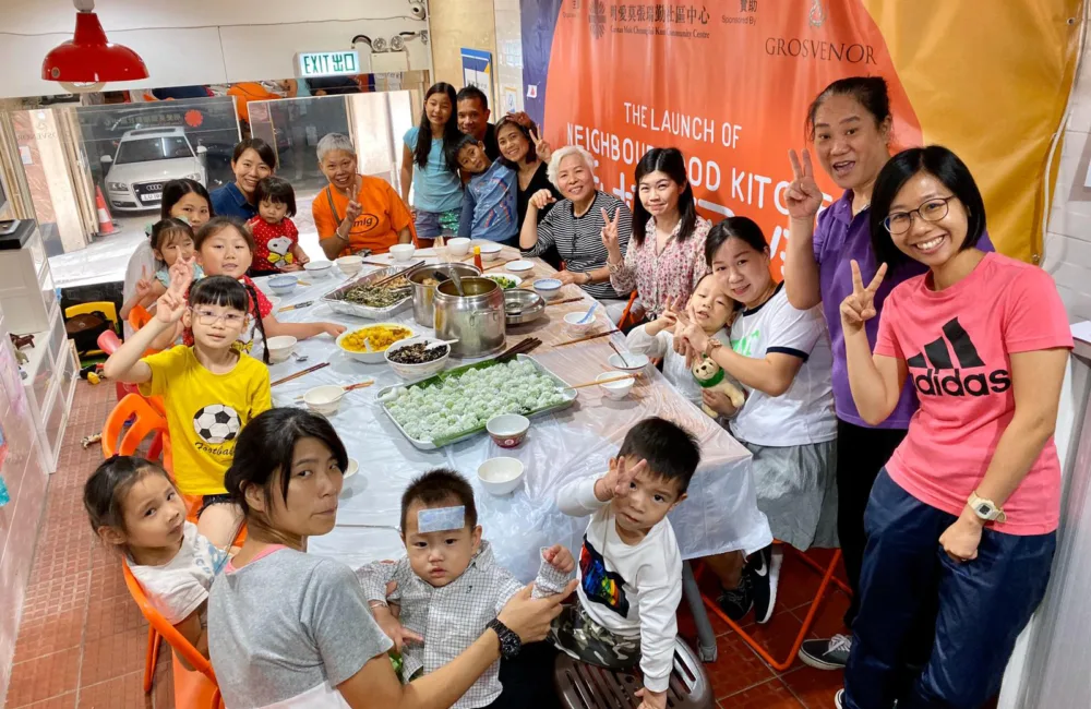 Families sat around a large table with food in the centre