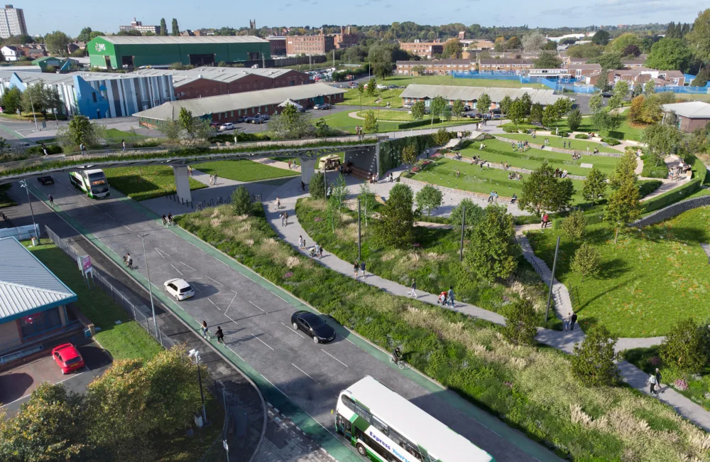 Aerial view of a road with walk ways in surrounding green space and a sky bridge